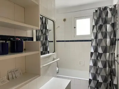 a bathroom with a black and white shower curtain at Cannes 100 mètres de la plage, entièrement climatisé in Cannes