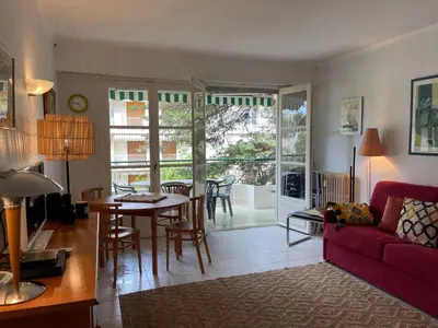 a living room with a red couch and a table at Cannes 100 mètres de la plage, entièrement climatisé in Cannes