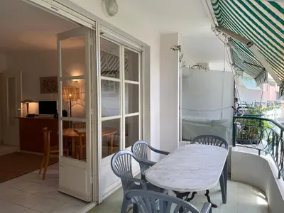 a table and chairs in a room with a window at Cannes 100 mètres de la plage, entièrement climatisé in Cannes