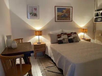 a bedroom with a bed and a desk with two lamps at Cannes 100 mètres de la plage, entièrement climatisé in Cannes
