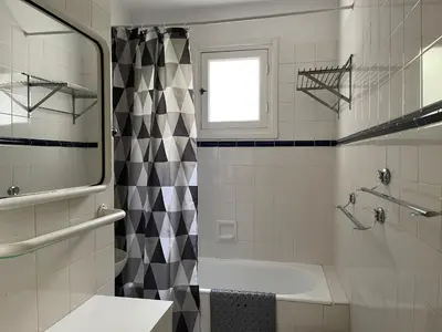 a bathroom with a sink and a tub and a window at Cannes 100 mètres de la plage, entièrement climatisé in Cannes