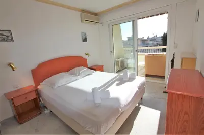 a bedroom with a large white bed and a window at Appartement 80 m2 au centre-ville de Cannes in Cannes