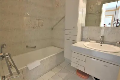 a bathroom with a sink and a bath tub and a sink at Appartement 80 m2 au centre-ville de Cannes in Cannes