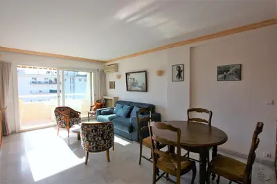 a living room with a blue couch and a table at Appartement 80 m2 au centre-ville de Cannes in Cannes