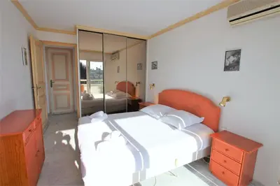 a bedroom with a large white bed and a mirror at Appartement 80 m2 au centre-ville de Cannes in Cannes