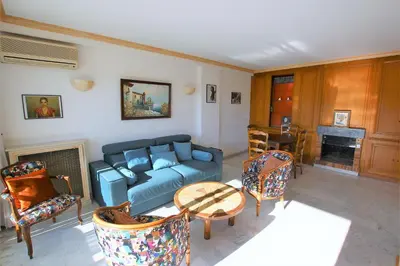 a living room with a blue couch and chairs at Appartement 80 m2 au centre-ville de Cannes in Cannes