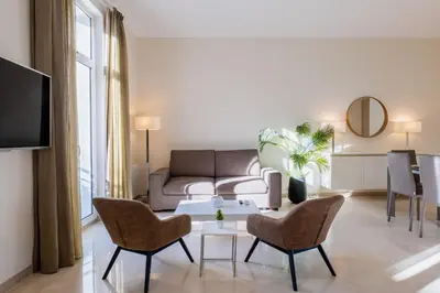 a living room with a couch and a table and chairs at 2-Br steps from the Palais des Festivals in Cannes
