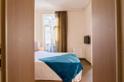 a bedroom with a bed with an umbrella on it at 2-Br steps from the Palais des Festivals in Cannes
