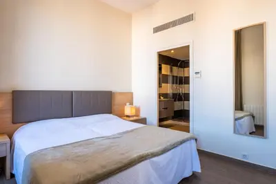 a bedroom with a large bed and a mirror at 2-Br steps from the Palais des Festivals in Cannes