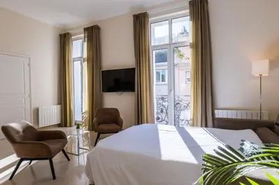 a bedroom with a bed and a large window at 2-Br steps from the Palais des Festivals in Cannes
