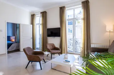 a living room with a couch chairs and a table at 2-Br steps from the Palais des Festivals in Cannes