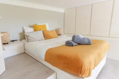 a bedroom with a large bed with an orange blanket at Beautiful Renovated Studio with AC and TERRACE - Benakey in Cannes