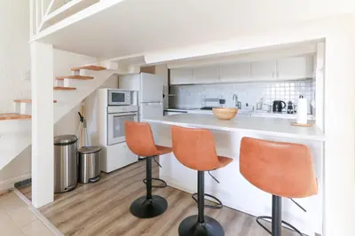 a kitchen with white cabinets and orange chairs at Beautiful Renovated Studio with AC and TERRACE - Benakey in Cannes