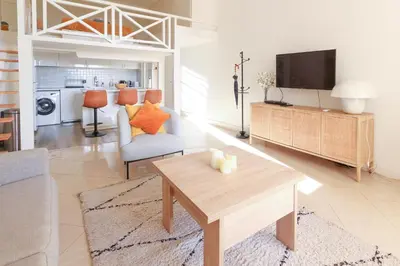 a living room with a table and a tv at Beautiful Renovated Studio with AC and TERRACE - Benakey in Cannes