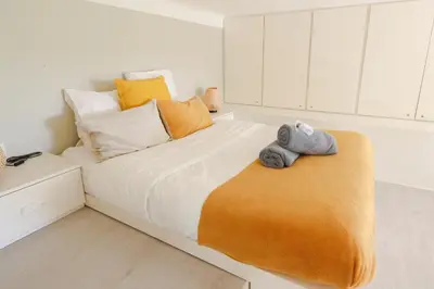 a white bedroom with a large bed with towels on it at Beautiful Renovated Studio with AC and TERRACE - Benakey in Cannes