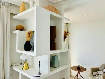 a living room with white shelves with vases at Superbe Penthouse avec vue panoramique sur la mer in Cannes