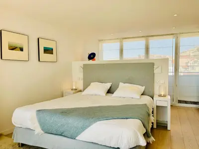 a bedroom with a large bed with white pillows at Superbe Penthouse avec vue panoramique sur la mer in Cannes