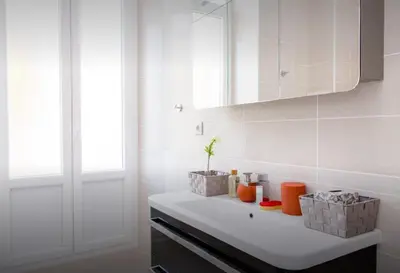 a white bathroom with a sink and a mirror at La Croisette in Cannes