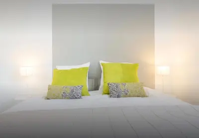 a white bed with two pillows and two lamps at La Croisette in Cannes
