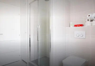 a white bathroom with a shower and a toilet at La Croisette in Cannes