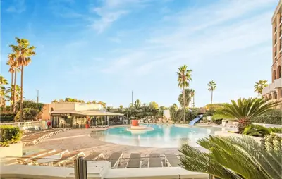 a large swimming pool with chairs and palm trees at 1 Bedroom Beautiful Apartment In Cannes in Cannes