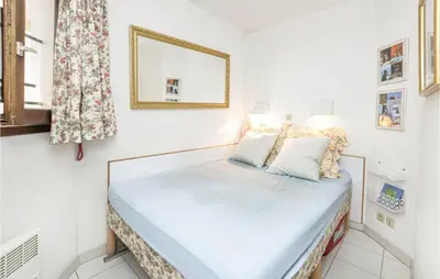 a small bedroom with a bed with a mirror at 1 Bedroom Beautiful Apartment In Cannes in Cannes