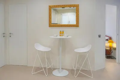 a table with two white stools and a mirror at Moderne 2 chambres, CARRE D'OR- COEUR DE CANNES A2B194 in Cannes