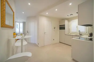 a white kitchen with a table and a counter at Moderne 2 chambres, CARRE D'OR- COEUR DE CANNES A2B194 in Cannes