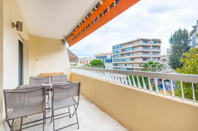 a balcony with two chairs and a view of a city at Agence des Résidences - Plein centre de Cannes in Cannes