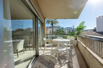 a balcony with a white table and chairs on it at Agence des Résidences - Plein centre de Cannes in Cannes