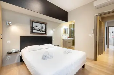 a bedroom with a large white bed and a bathroom at Agence des Résidences - Plein centre de Cannes in Cannes