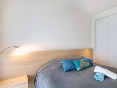 a bedroom with a bed with a wooden headboard at Apartment Cristal Croisette-4 by Interhome in Cannes
