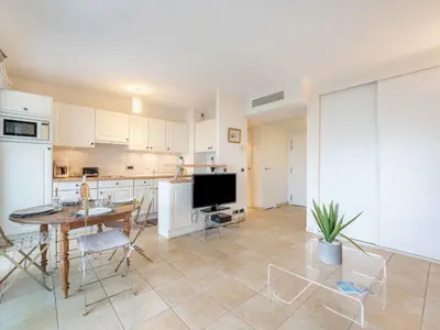 a kitchen and living room with a table and a tv at Apartment Cristal Croisette-4 by Interhome in Cannes