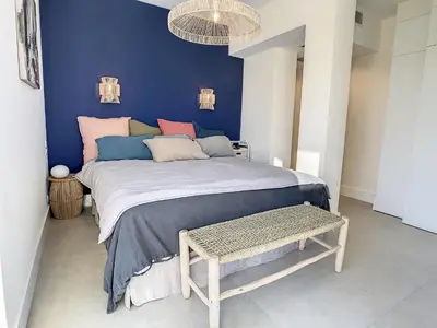 a bedroom with a large bed with blue walls at Penthhouse 1 & 2 bedroom apartment 2 mins from the Croisette 335 in Cannes