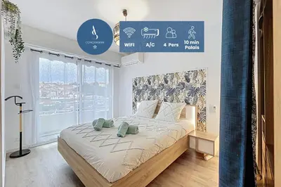 a bedroom with a large bed with two pillows on it at Le Brasilia - 4 pers - 10 min Palais - Climatisé - Centre in Cannes