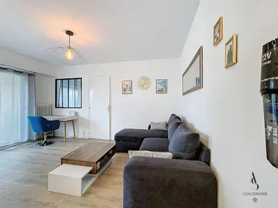 a living room with a couch and a table at Le Brasilia - 4 pers - 10 min Palais - Climatisé - Centre in Cannes