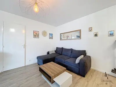 a living room with a blue couch and a table at Le Brasilia - 4 pers - 10 min Palais - Climatisé - Centre in Cannes