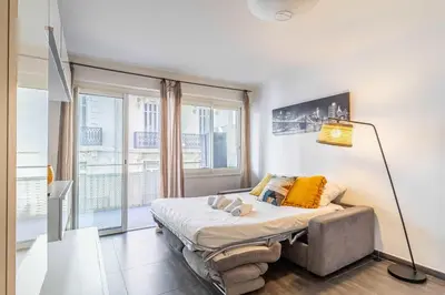 a bedroom with a bed and a large window at Beautiful apartment with balcony - Center Cannes in Cannes
