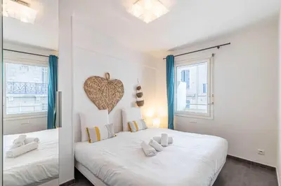 a bedroom with a large white bed with a heart on the wall at Beautiful apartment with balcony - Center Cannes in Cannes