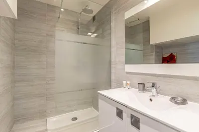 a white bathroom with a sink and a shower at Beautiful apartment with balcony - Center Cannes in Cannes