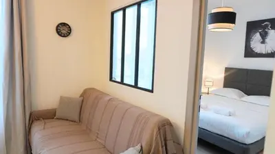a living room with a couch and a bed and a mirror at Proche Carlton & Croisette, Appartement 301 - Palmazur Vacances in Cannes