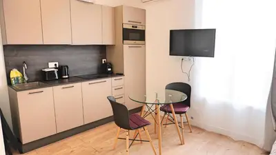 a small kitchen with a glass table and chairs at Proche Carlton & Croisette, Appartement 301 - Palmazur Vacances in Cannes