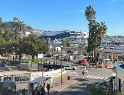 a city with a street with cars and a parking lot at Appartement 33 m2 comme une junior suite - vue Port et Palais des festivals in Cannes