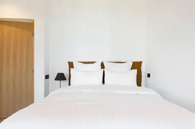 a bedroom with a white bed with white sheets and pillows at Appartement 33 m2 comme une junior suite - vue Port et Palais des festivals in Cannes
