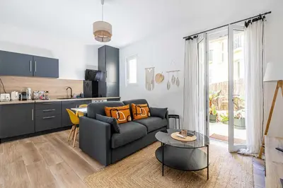 a living room with a couch and a kitchen at Résidence Palais des Festivals - Cannes centre in Cannes