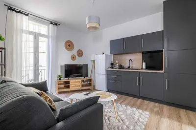a living room with a couch and a kitchen at Résidence Palais des Festivals - Cannes centre in Cannes
