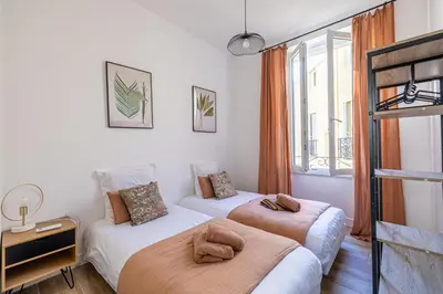 two beds in a room with a window at Résidence Palais des Festivals - Cannes centre in Cannes