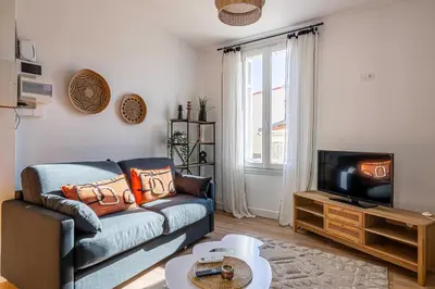 a living room with a couch and a tv at Résidence Palais des Festivals - Cannes centre in Cannes