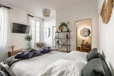 a bedroom with a large white bed and a mirror at Résidence Palais des Festivals - Cannes centre in Cannes