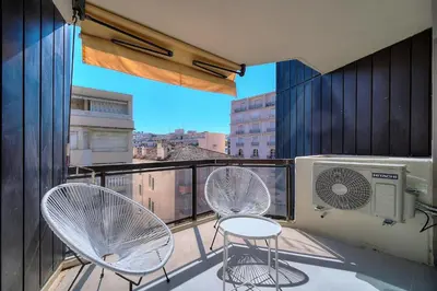 a balcony with two chairs and a air conditioner at REF 1745 - Cannes Center - Studio for rent in Cannes